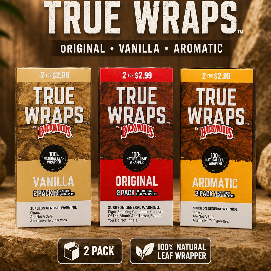 Three Backwoods by Paper Dog True Wraps 2-pack boxes shown on a rustic wood background with rocks. The packages are labeled Vanilla, Original, and Aromatic, 